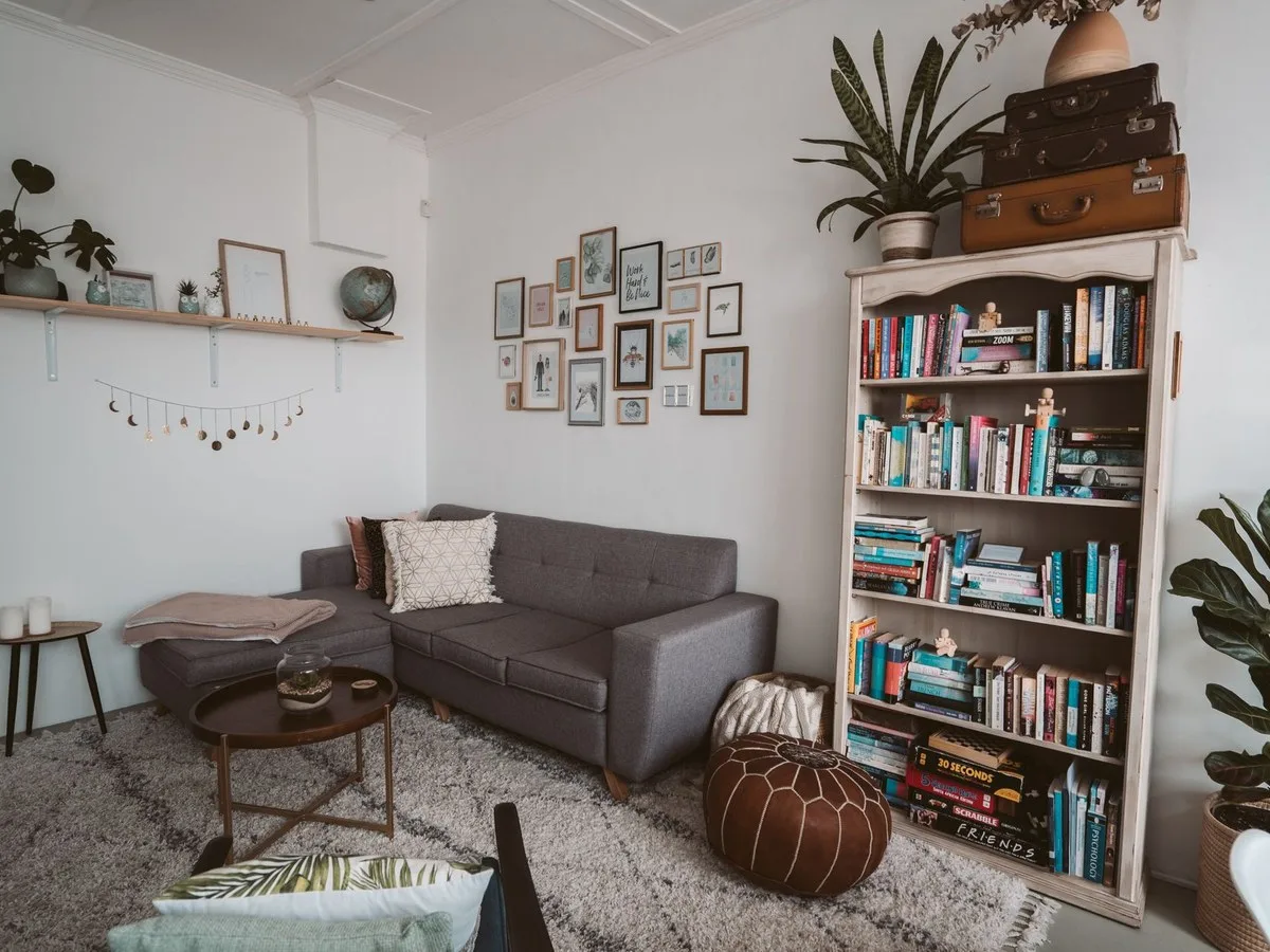 Wohnzimmer mit Sofa, Tisch und Regal für verschiedene Nutzungen.