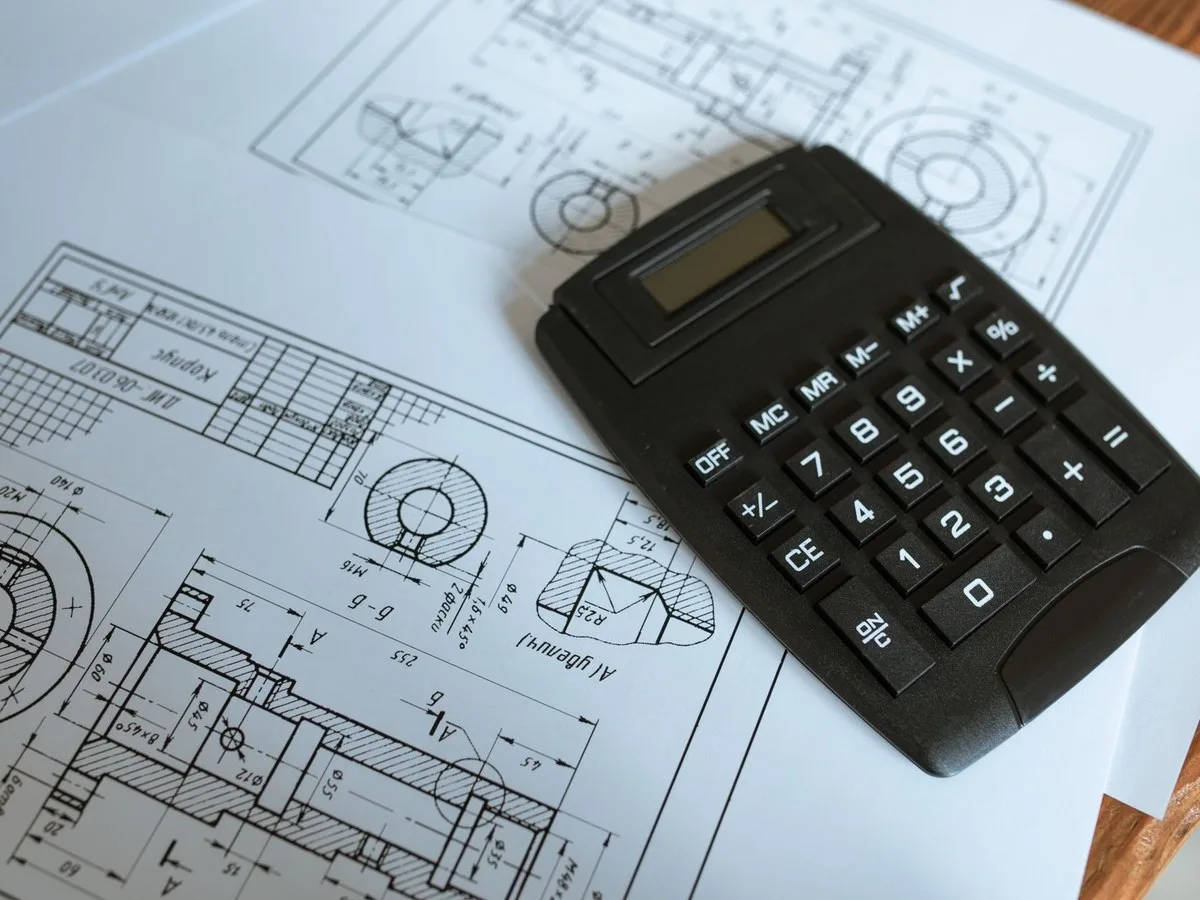 Calculatrice sur des plans pour comparer quantités et coûts.